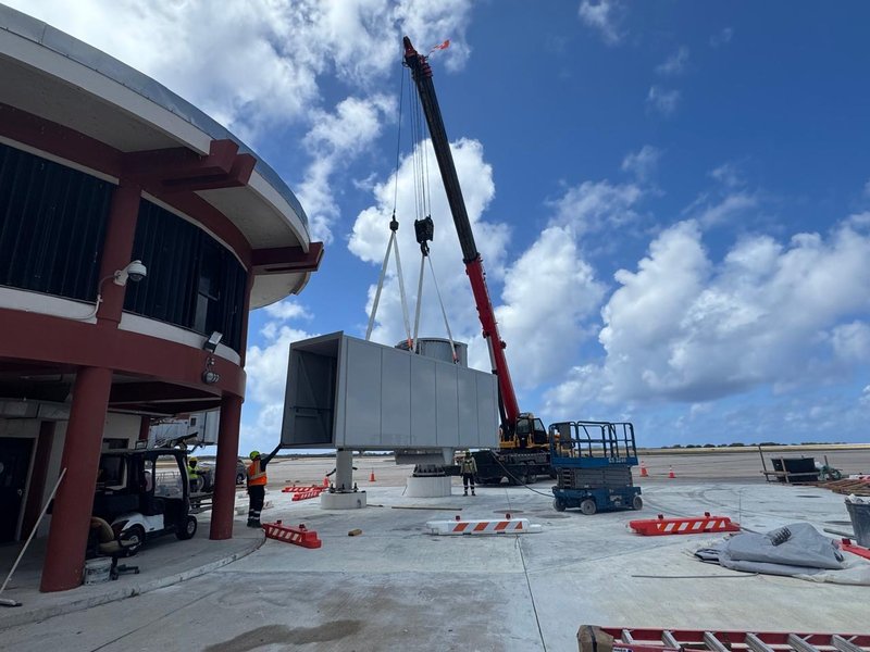 Crane lifting passenger boarding bridge at Saipan airport