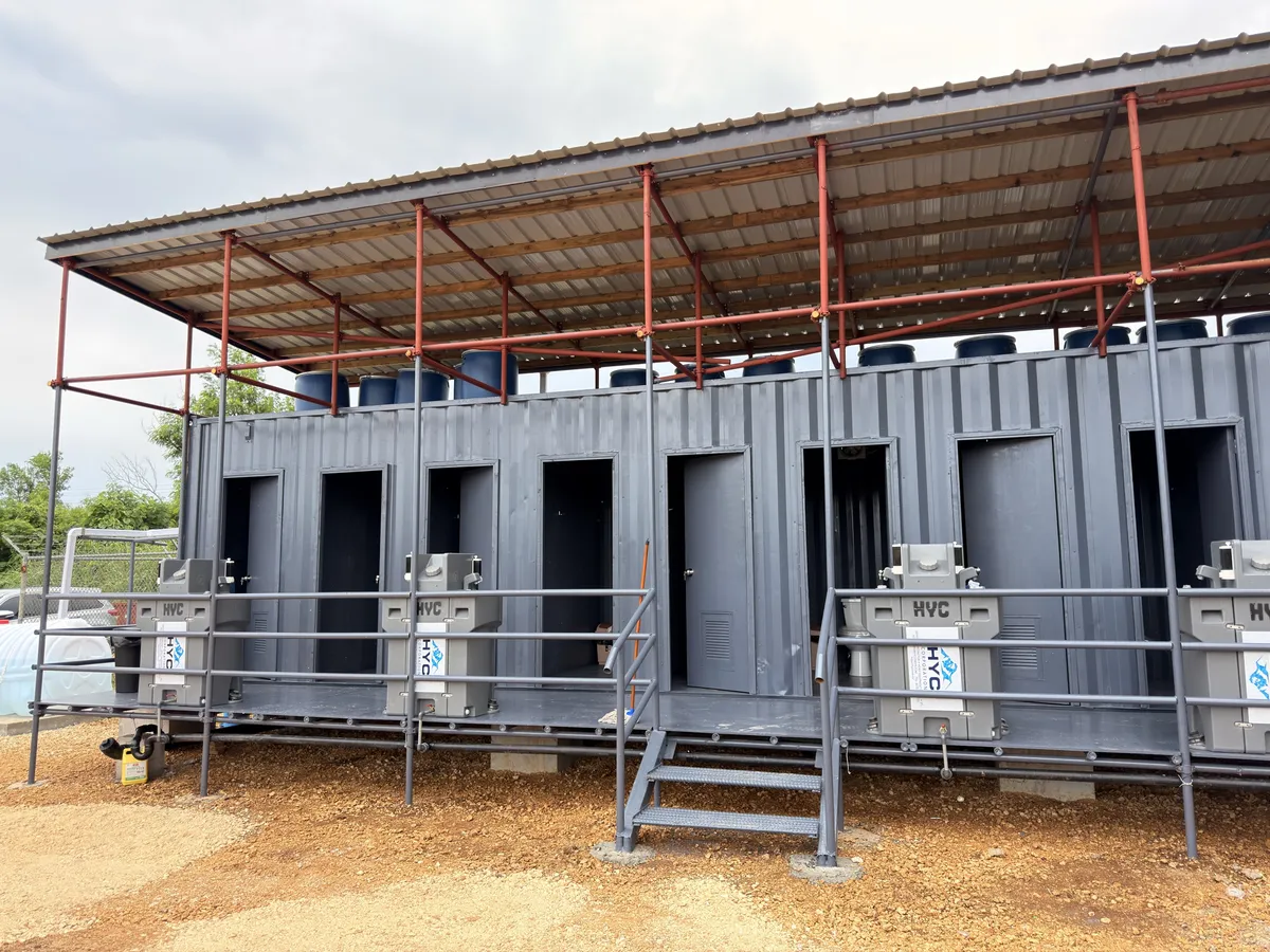 Row of HYC container restroom units under a shade canopy