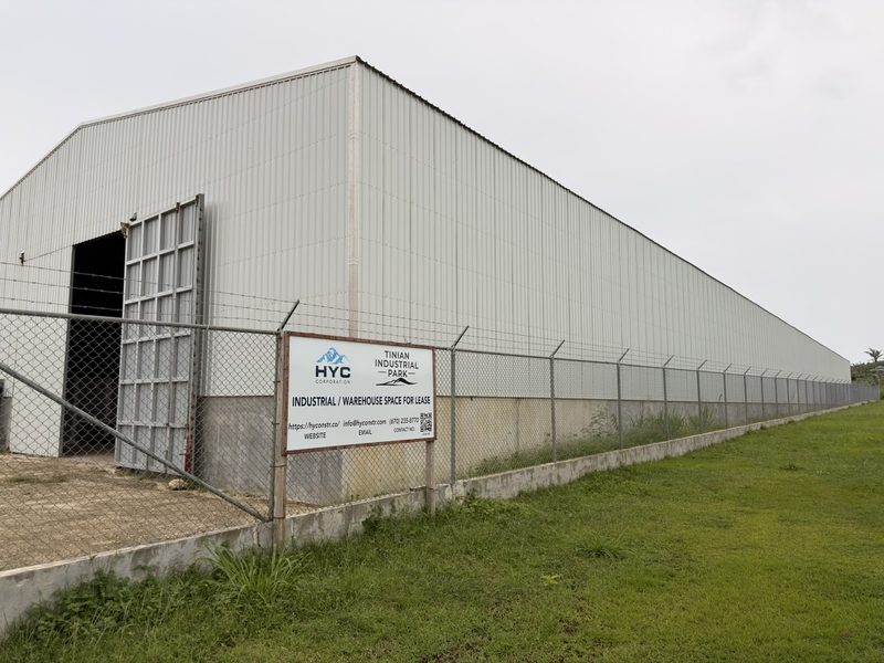 HYC warehouse at Tinian Industrial Park, perimeter-fenced, with industrial and warehouse space for lease signage