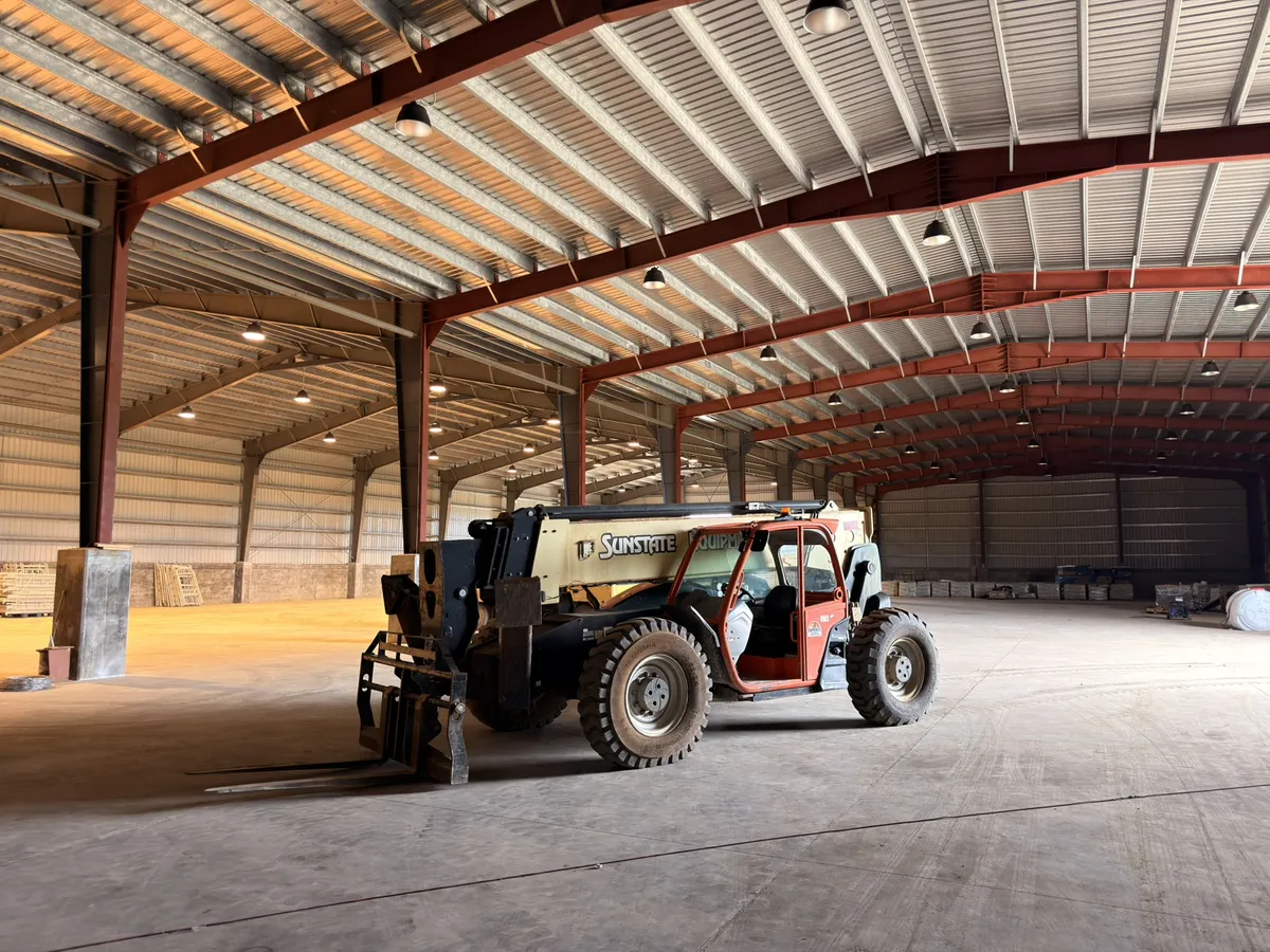 Interior of the HYC Tinian warehouse with a telehandler on the concrete floor